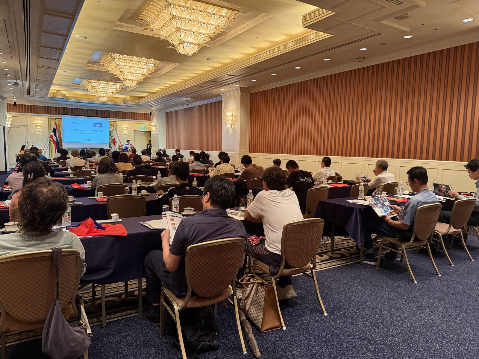 Speaker stage and projector screens inside the Japan Road Show 2026 Osaka venue at Imperial Hotel Osaka