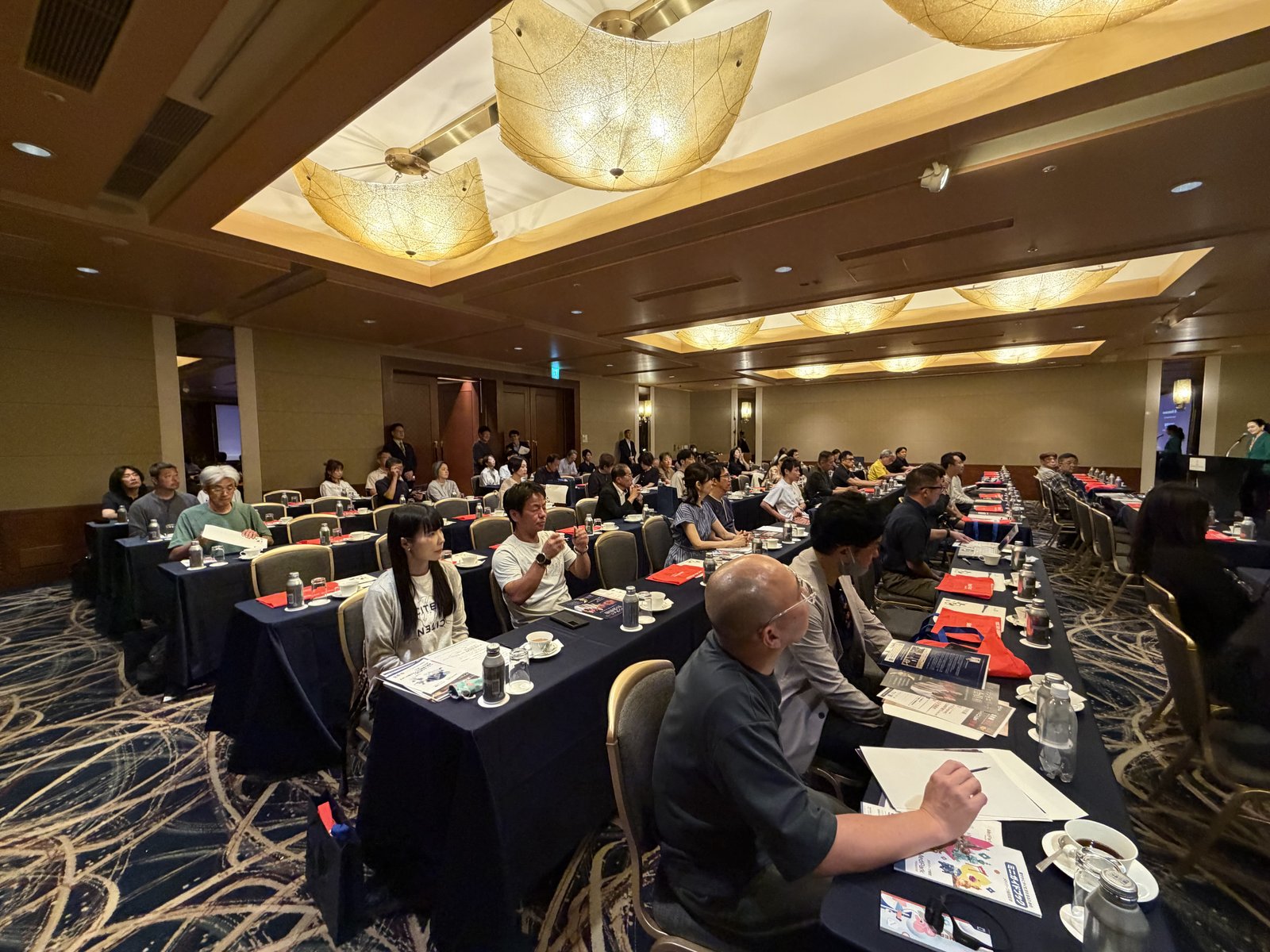 Speaker stage and projector screens inside the Japan Road Show 2026 Tokyo venue at ANA InterContinental Tokyo